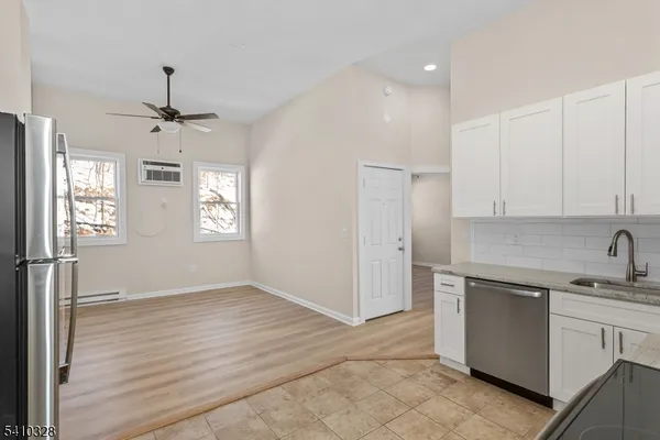 a kitchen with a sink stainless steel appliances cabinets and a window
