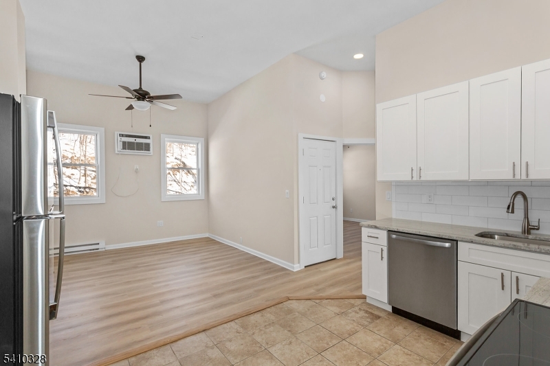 129 Main Street, Unit 3 Bloomingdale, NJ 07403 - Photo 8 of 21 a kitchen with a sink stainless steel appliances cabinets and a window