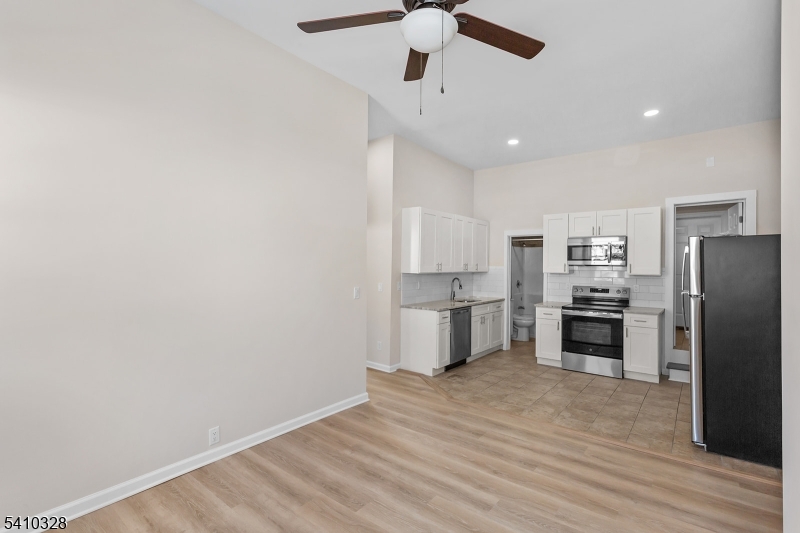 129 Main Street, Unit 3 Bloomingdale, NJ 07403 - Photo 10 of 21 a kitchen with stainless steel appliances a refrigerator and a stove top oven