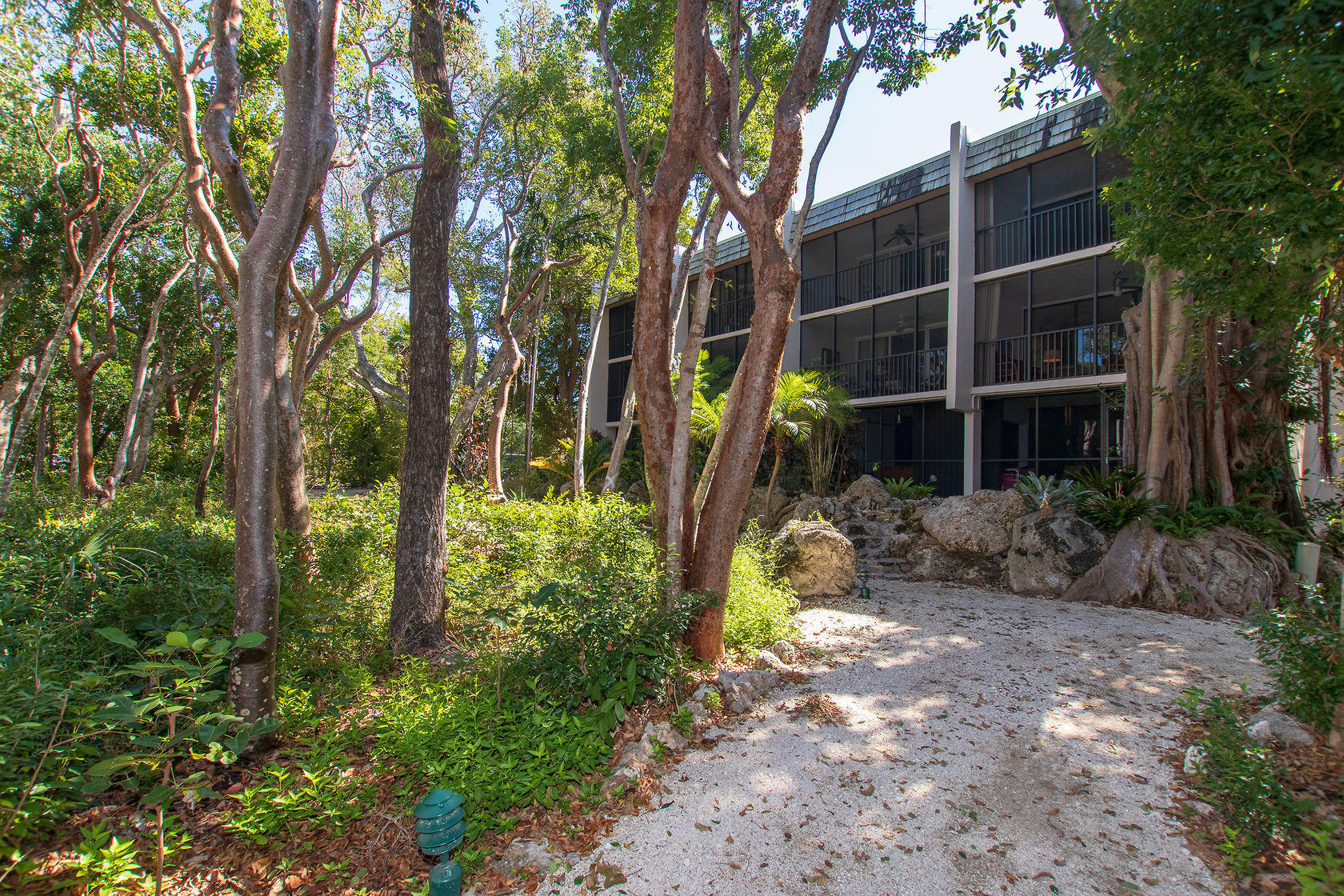 97652 Overseas Highway, Unit M11 Key Largo, FL 33037 - Photo 40 of 48 a front view of a house with a yard and potted plants