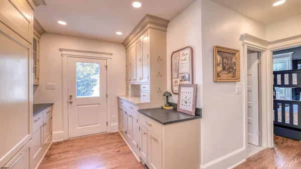 a hallway with cabinets a wooden floor and a large window