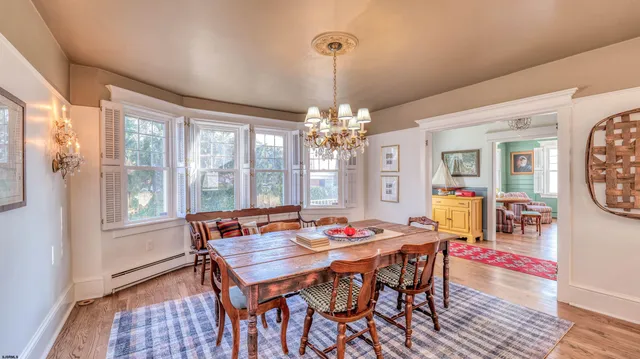 a kitchen with stainless steel appliances granite countertop a sink a stove a refrigerator a dining table and chairs