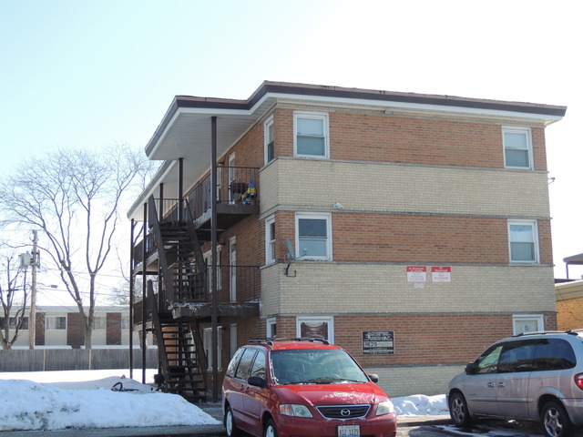 77 North Wolf Road Wheeling, IL 60090 - Photo 1 of 8 a front view of a building with cars parked