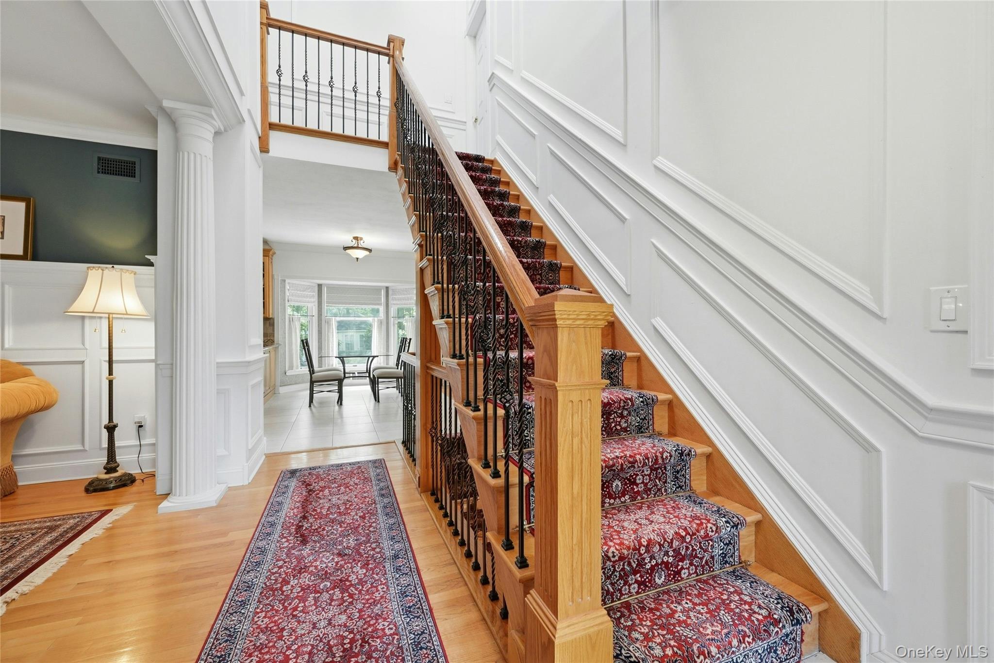 6 Thunder Road Miller Place, NY 11764 - Photo 12 of 50 Welcomed By An Exquisite Formal Entrance Foyer Offering A Stunning Two Story Stairway To To The Second Level With Custom Oak & Wrought Iron Bannisters, Railings, Spindles & Stairs, Magnificent Fully Floor To Ceiling Box Paneled/Wainscoted Walls, Beautiful Hardwood Floors, A Two Column Entrance Into The Formal Living Room & Then Opens Into The Kitchen, Dinette And Den/Family Room.