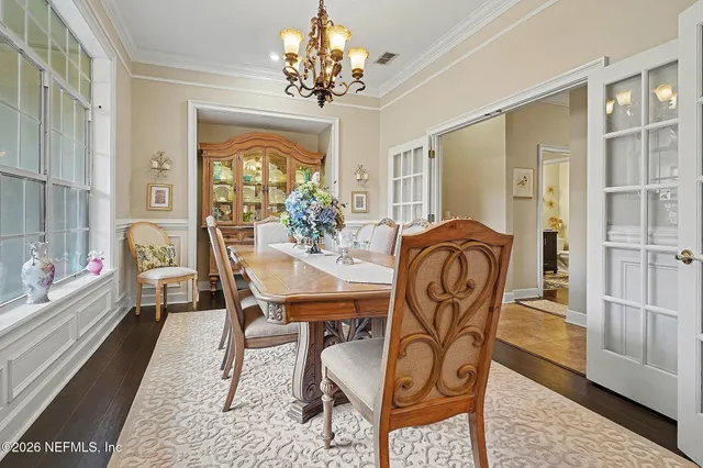 a dining room with furniture a chandelier and wooden floor