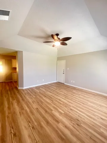a view of empty room with wooden floor