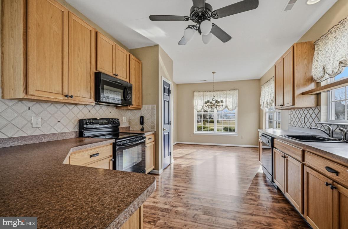 304 Daylilly Way Middletown, DE 19709 - Photo 8 of 20 a kitchen with stainless steel appliances granite countertop a stove a sink and a microwave