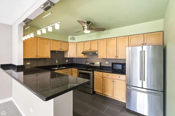 a kitchen with stainless steel appliances granite countertop a sink stove and cabinets