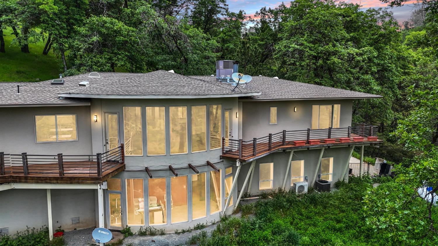 a view of a house with pool and chairs under an umbrella