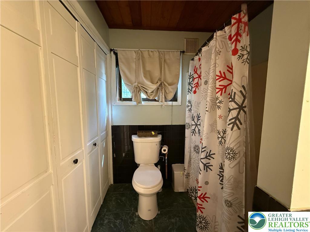 193 Canterbury Road Bushkill, PA 18324 - Photo 9 of 32 a bathroom with a toilet and a shower curtain