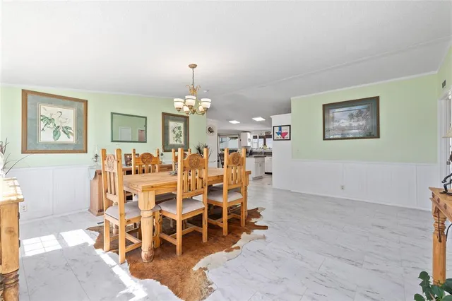 a view of a dining room with furniture and chandelier