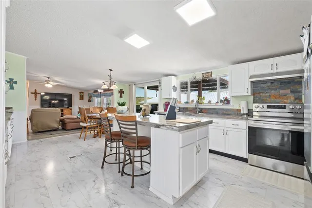 a kitchen with stainless steel appliances kitchen island granite countertop a sink and cabinets