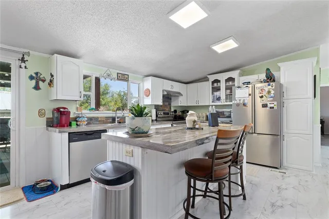 a kitchen with granite countertop cabinets and refrigerator