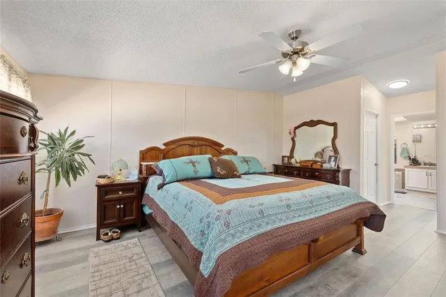 a bedroom with a large bed and a chandelier