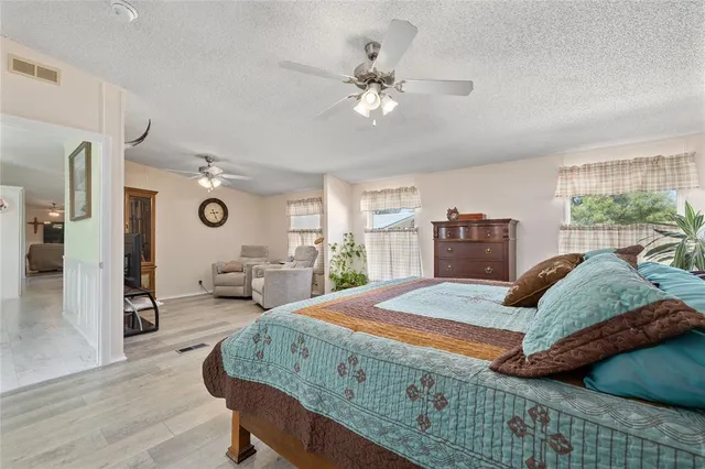 a bedroom with a large bed chandelier and a window