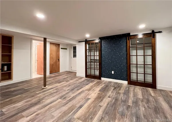 a view of an empty room with wooden floor and closet