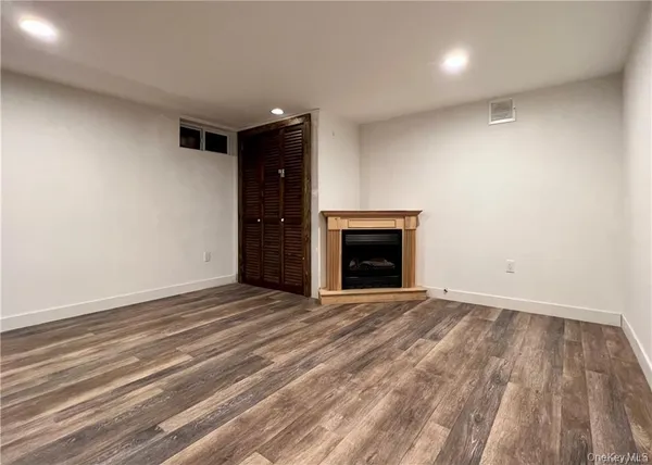 a view of empty room with wooden floor and fireplace