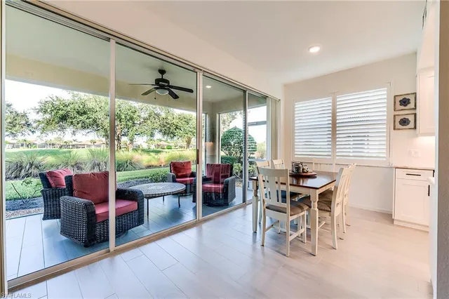 a living room with furniture a floor to ceiling window and wooden floor
