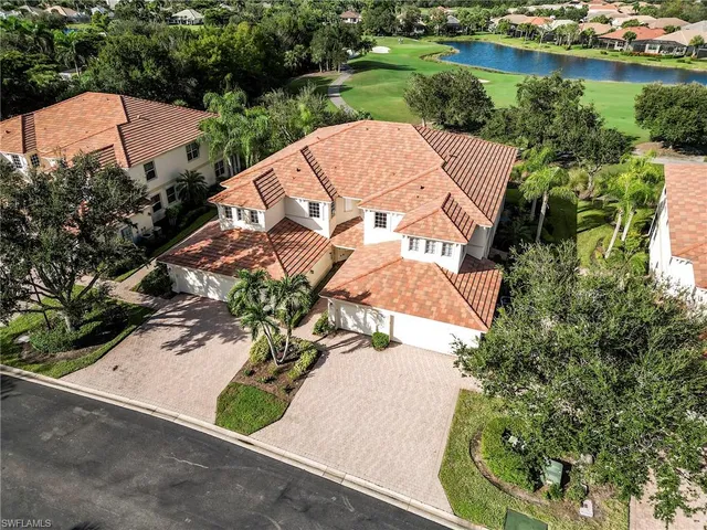an aerial view of a house with a garden and lake view