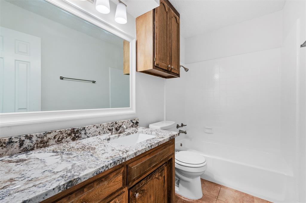 921 Red Oak Street Azle, TX 76020 - Photo 12 of 16 Full bath featuring vanity, shower / washtub combination, and light tile patterned floors