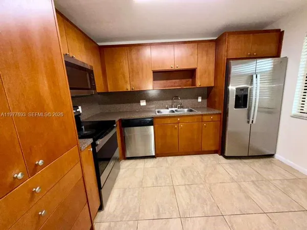 a kitchen with stainless steel appliances granite countertop a stove a sink and a refrigerator