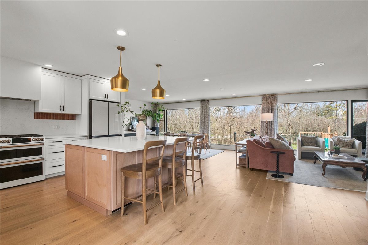 1975 Valley View Road Northfield, IL 60093 - Photo 14 of 45 a kitchen with stainless steel appliances granite countertop a stove oven and a dining table with wooden floor