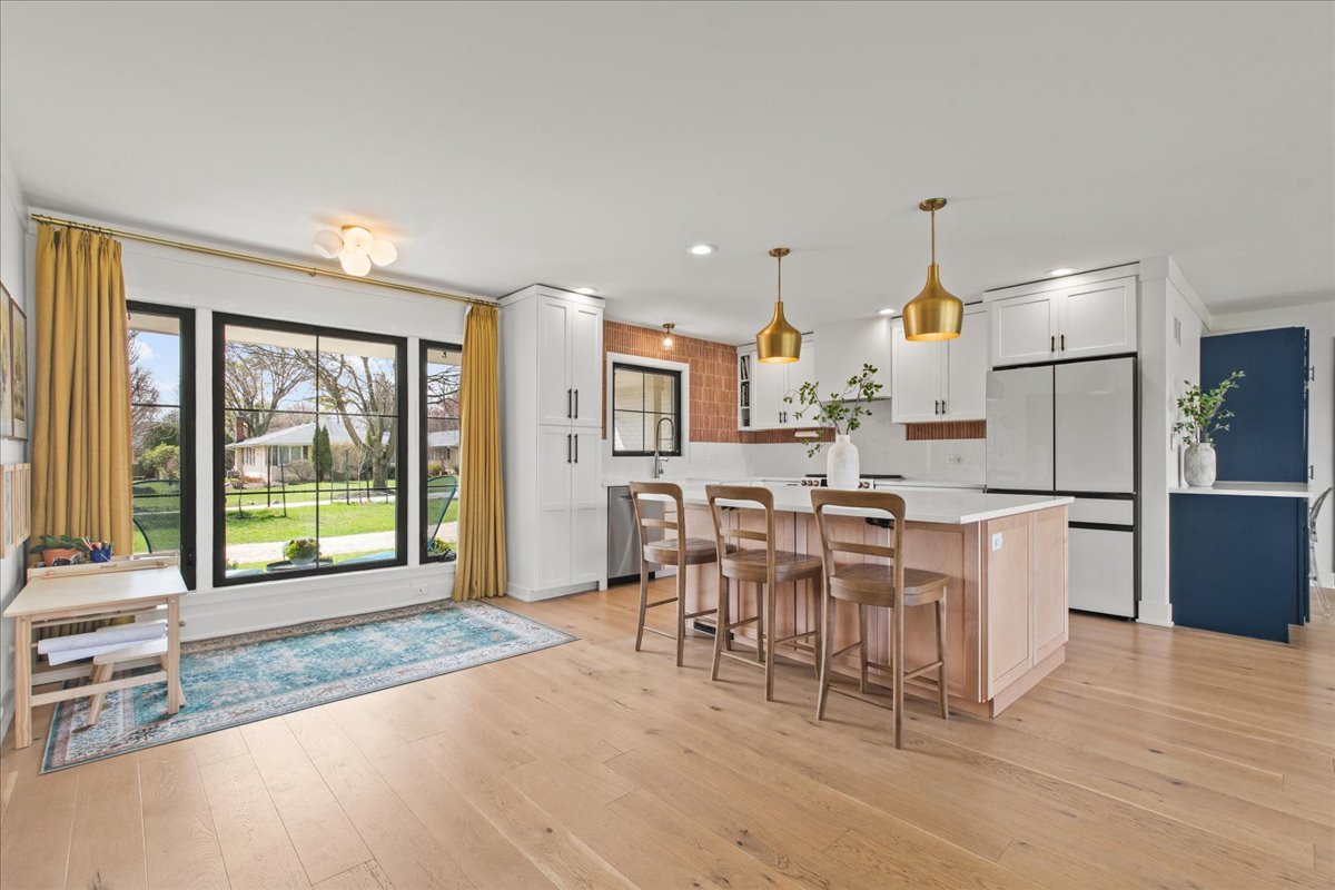 1975 Valley View Road Northfield, IL 60093 - Photo 9 of 45 a kitchen with stainless steel appliances a dining table chairs and a large window