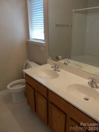 a bathroom with a sink toilet and a mirror