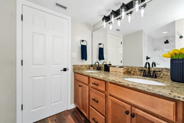 a bathroom with a granite countertop sink and a mirror