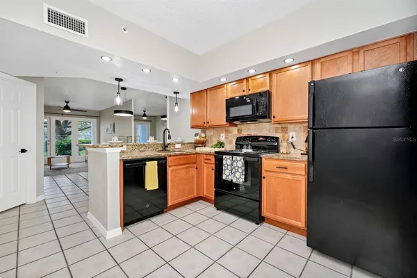 a kitchen with stainless steel appliances granite countertop a refrigerator sink and stove