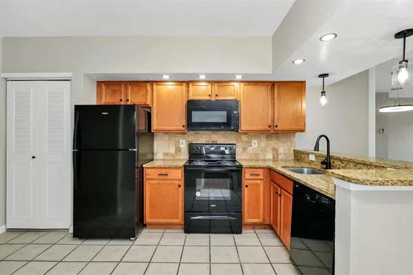 a kitchen with stainless steel appliances granite countertop a refrigerator and a stove