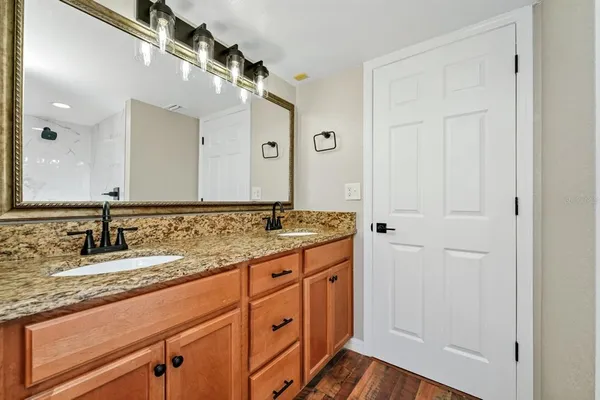 a bathroom with a granite countertop sink and a mirror