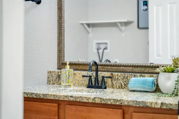 a bathroom with a granite countertop sink and a mirror