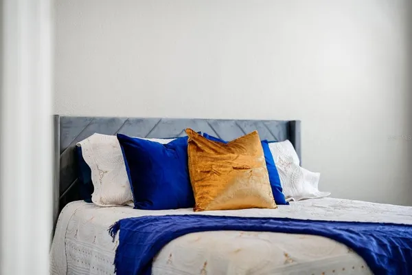 a bedroom with a bed and painting on the wall