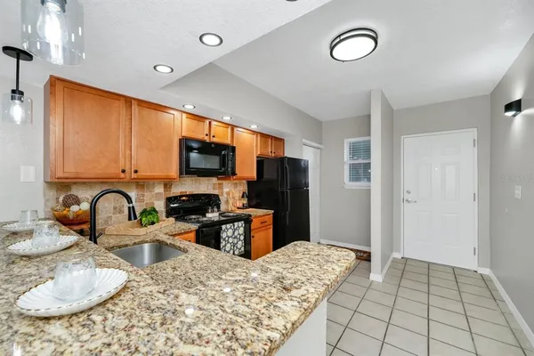 a kitchen with sink a refrigerator and a stove top oven