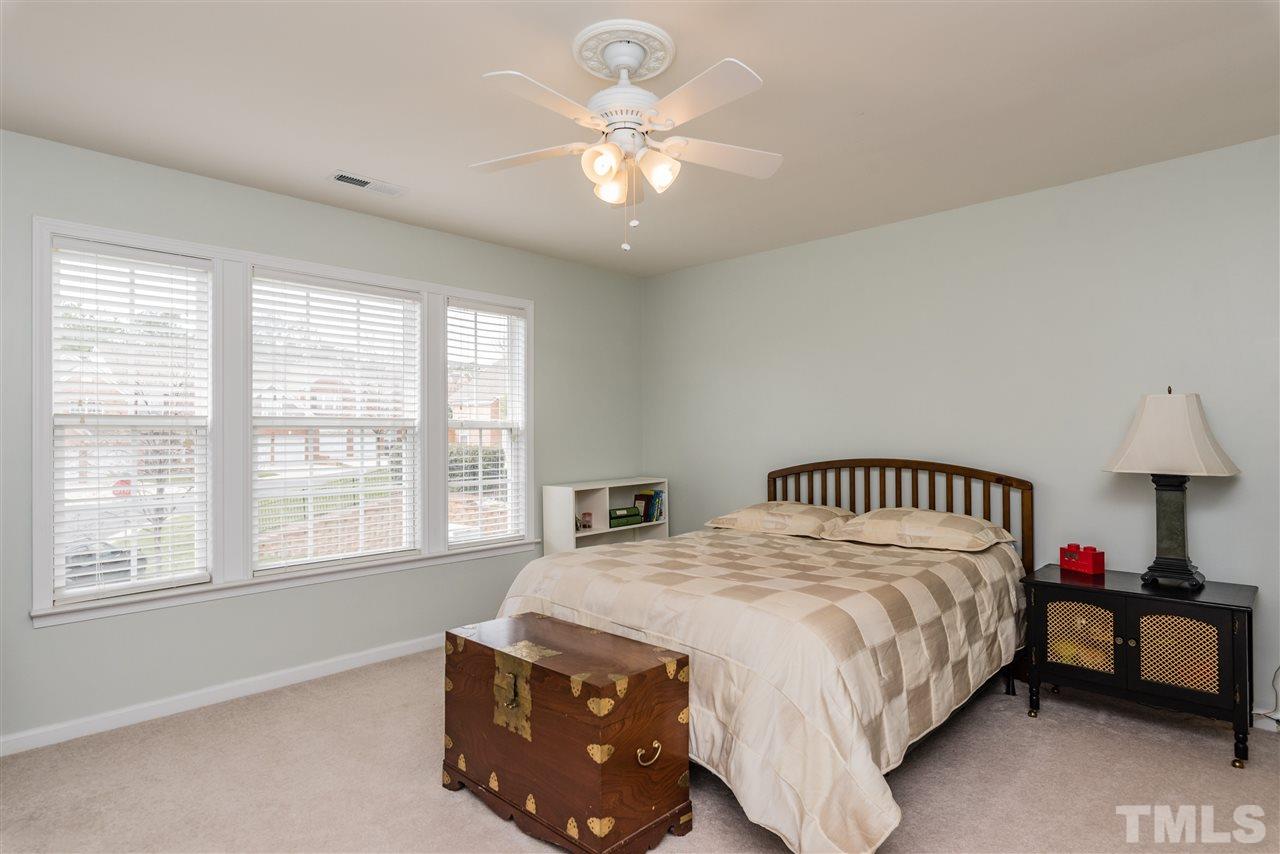 5112 Kate Denson Way Raleigh, NC 27612 - Photo 21 of 25 a bedroom with a bed and a chandelier