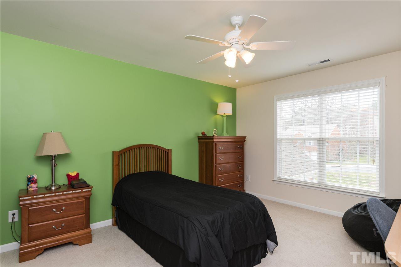 5112 Kate Denson Way Raleigh, NC 27612 - Photo 23 of 25 a bedroom with a bed and a chandelier