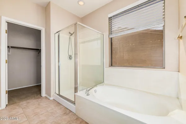a bedroom with a bed and a flat tv screen on dresser