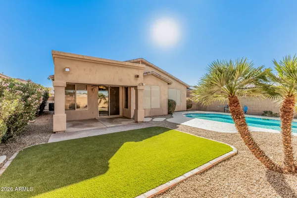 a view of a house with pool and a yard