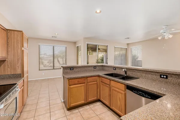 a kitchen that has a sink a stove and chairs