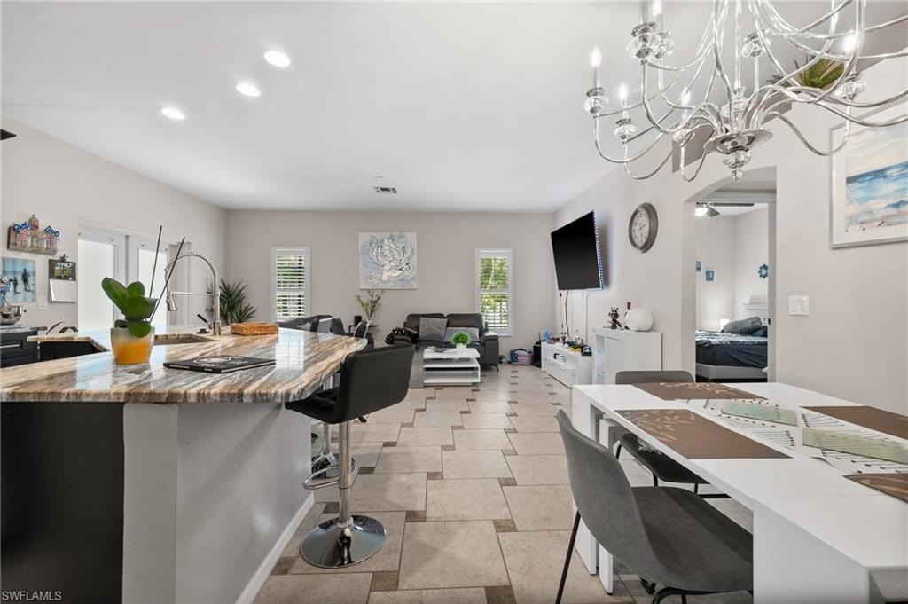 2017 Cape Coral Parkway West Cape Coral, FL 33914 - Photo 34 of 35 Kitchen featuring a kitchen bar, recessed lighting, open floor plan, a chandelier, and a center island with sink