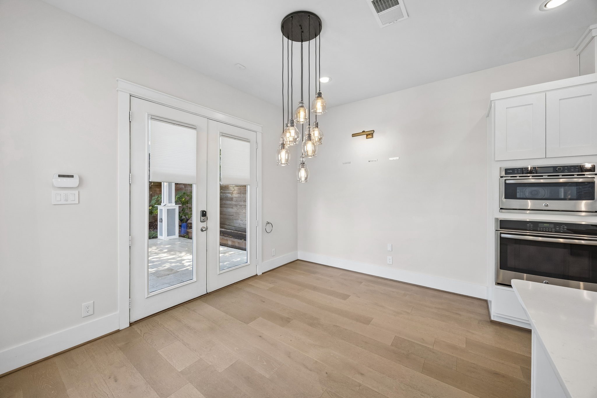8558 Ridgepoint Drive Houston, TX 77055 - Photo 6 of 39 A cluster of glass pendants defines this intimate dining space, with French doors connecting the kitchen to the outdoors.