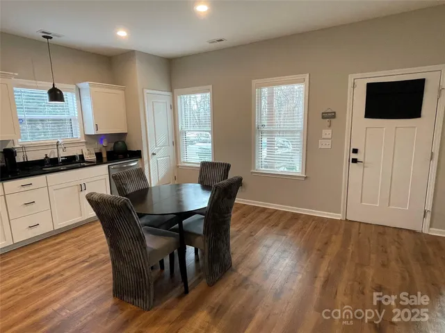 a kitchen with granite countertop a dining table chairs and flat screen tv