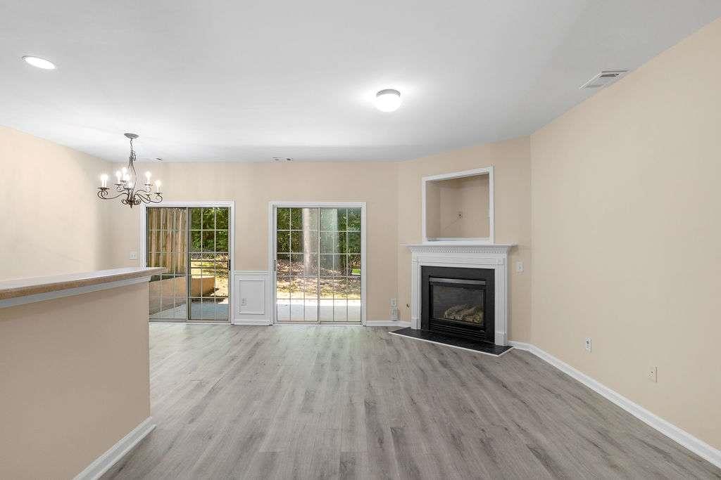 2757 Keystone Avenue Lithonia, GA 30058 - Photo 4 of 28 an empty room with wooden floor fireplace and windows