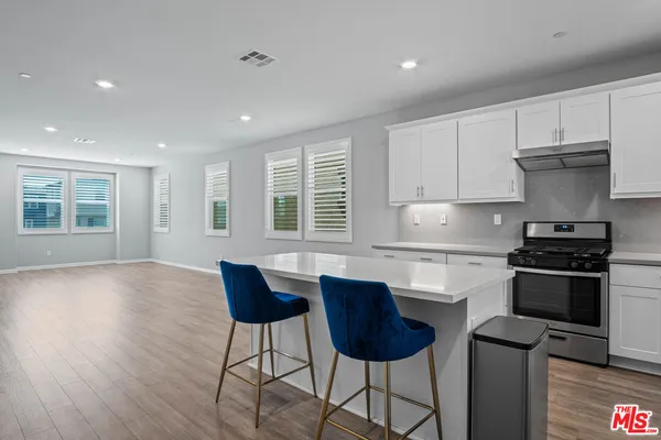 a kitchen with stainless steel appliances granite countertop a stove and a refrigerator