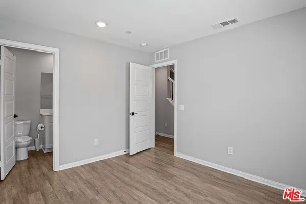 a view of a room with wooden floor and a bathroom