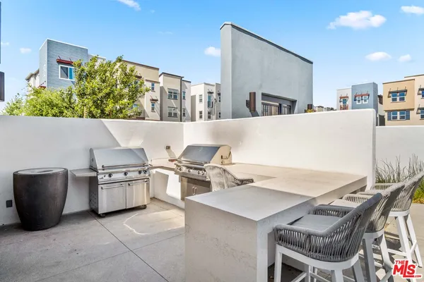 a living room with stainless steel appliances kitchen island granite countertop a table and chairs in it