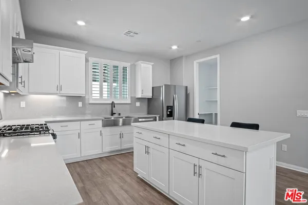 a kitchen with white cabinets and white appliances