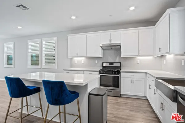 a kitchen with stainless steel appliances granite countertop a stove a sink dishwasher and a refrigerator