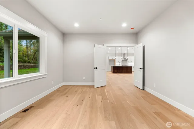 a view of empty room with wooden floor and windows
